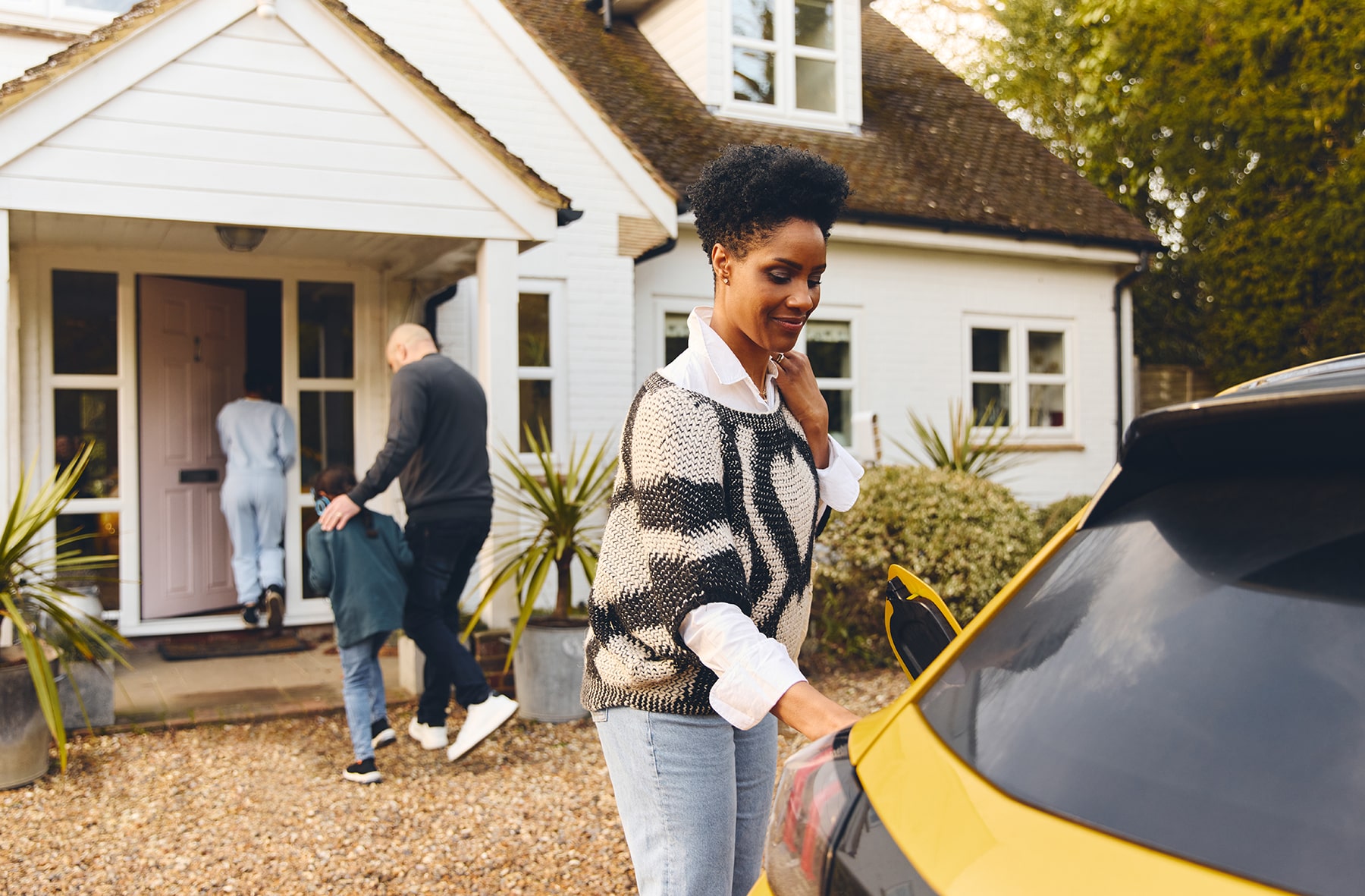 woman-charging-electric-car-ev-on-driveway-outside-2023-03-24-21-16-25-utc-min